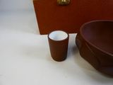 a brown bowl and a cup sitting next to each other