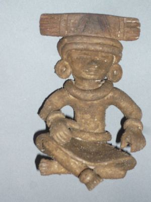 une petite statue d'un homme avec un chapeau sur la tête