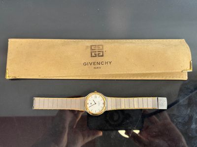 someone is holding a watch in front of a box with a watch on it