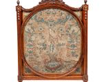 an image of a wooden bed with a tapestry on the headboard