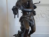 une statue représentant une femme tenant un oiseau sur une table