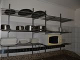 shelves with pots and pans on them in a kitchen with granite counter tops