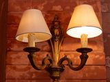 two lamps that are on the wall next to a brick wall