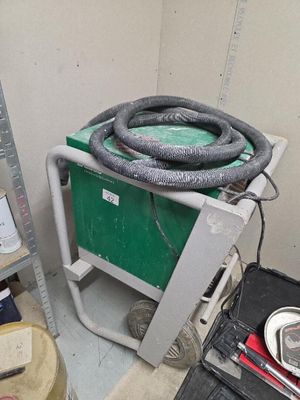 une photo d'une pièce avec un chariot vert et des outils
