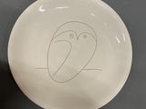 a white plate with a drawing of an owl on it
