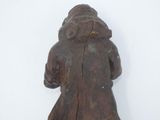 a wooden statue of a man with a hat and coat