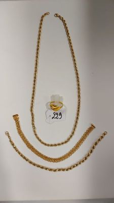 Deux chaînes en or et un collier en or sont exposés dans une vitrine.