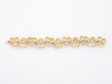 a gold bracelet with yellow and white stones on a white background