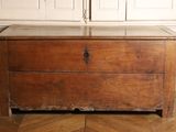 a wooden chest sitting on a parquet floor in a room