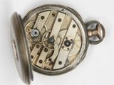 a close up of a pocket watch on a white surface