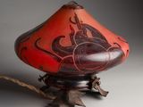 an image of a red and black vase on a stand