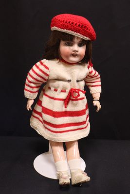 a doll that is wearing a red and white striped dress and hat