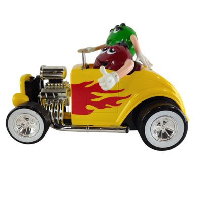 une petite voiture jaune et rouge sur laquelle est assis un homme portant un casque vert