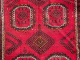 a close up of a red rug on a wooden floor