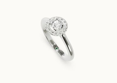 gros plan d'une bague en diamant et émeraude sur fond blanc