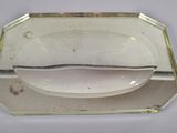a glass tray with a spoon on it on a table