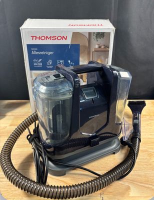 un gros plan d'un aspirateur posé sur une table, à côté d'une boîte