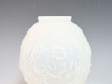 a white vase sitting on a table with a gray background