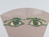 deux yeux verts qui se trouvent sur le côté d'un miroir