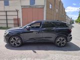 the black suv is parked on the side of the road in front of a building