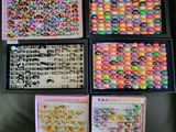 four boxes filled with different types of plastic beads