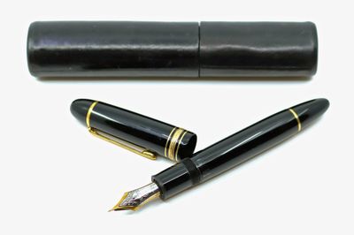 un stylo noir et un étui noir posés sur une surface blanche