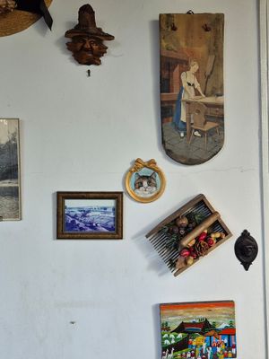 de nombreuses photos accrochées au mur d'une cuisine où se trouve un réfrigérateur