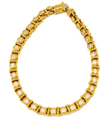 an image of a gold bracelet with white stones on it