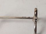 a small silver object on a white surface