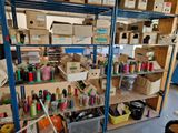 many different colored spools on the shelves in the room