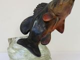 statue représentant un black-bass à grande bouche posé sur un rocher, sur un fond blanc