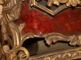 a gold and red clock on display in a room