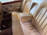 a seat in the back of a car that has a pillow on it