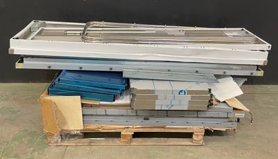 une pile de tôles métalliques posée sur une palette dans un entrepôt