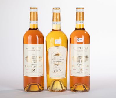 trois bouteilles de vin posées les unes à côté des autres sur une surface blanche
