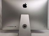 a silver apple computer sitting on a white table