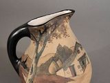 a vase with a painting on it sitting on a table