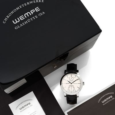 une boîte noire posée sur une table, contenant une montre