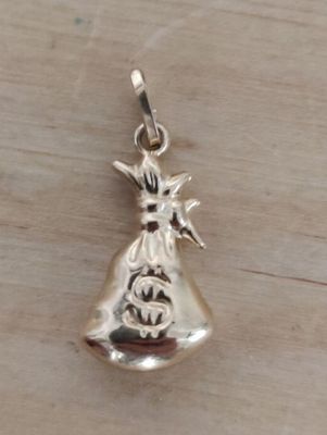 breloque plaquée argent représentant un chat assis dans un sac posé sur une table