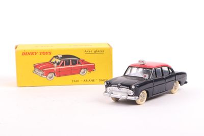 a small toy car next to a box on a white surface