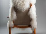 an image of a chair with a white fur on the back