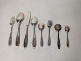 several spoons, forks, and spoons are lined up on a table