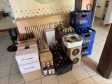 de nombreuses bouteilles de vin et des cartons de bière par terre
