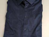 une chemise bleue posée sur une table blanche