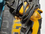 a yellow corded drill and a black corded hammer on a table