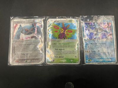 three different pokemon trading cards on a black table