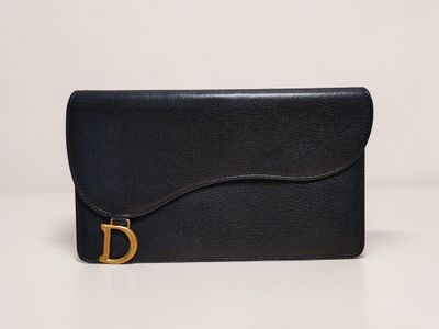 a black leather clutch bag with a gold buckle on the front