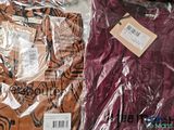 two shirts that are wrapped in plastic on a table