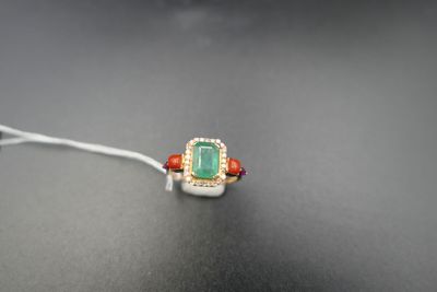 a close up of a green and red ring on a black surface