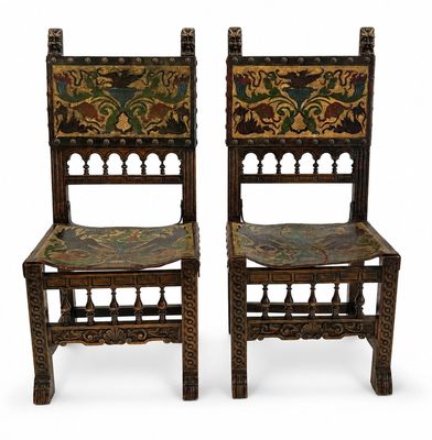 pair of carved chairs with floral designs on the backs